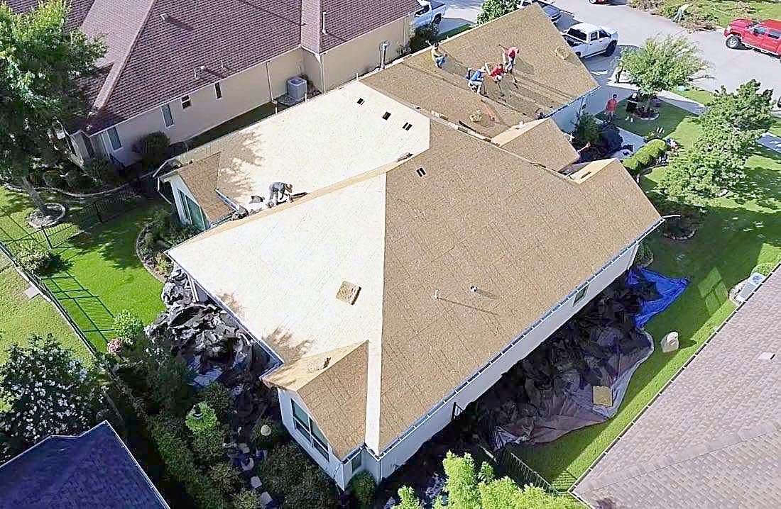 Overhead view of a roof stripped to new plywood decking during a replacement