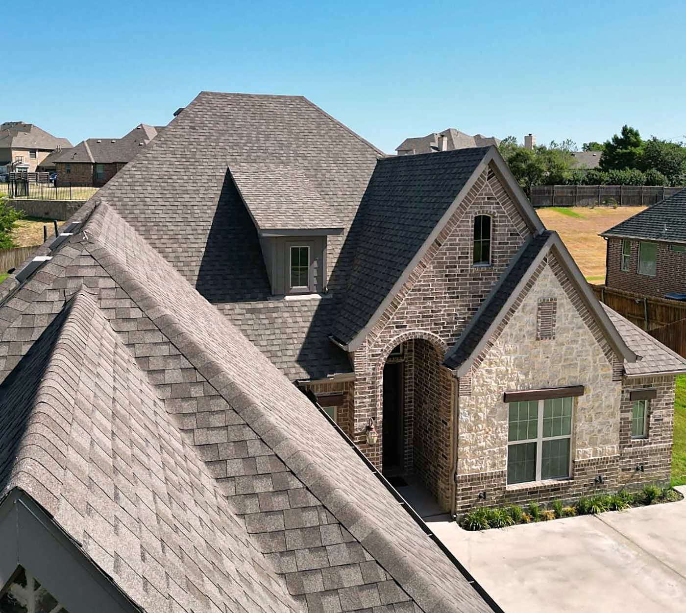 Close view of a stone gable and the shingle roof beside it